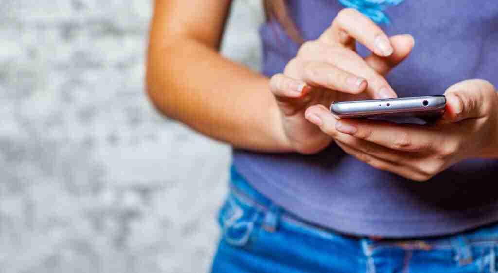 Women holding phone at waist and texting for junk removal quote