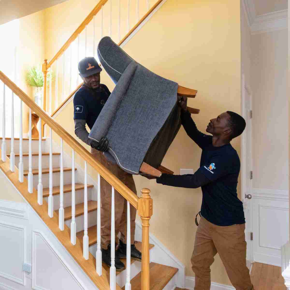 Trash and Stash team carrying chair down stairs