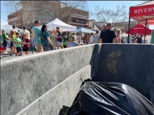 Event cleanup crew pushing trash cart through crowded street festival in Charlotte NC