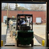 Forklift removing industrial equipment during warehouse cleanout in Charlotte NC